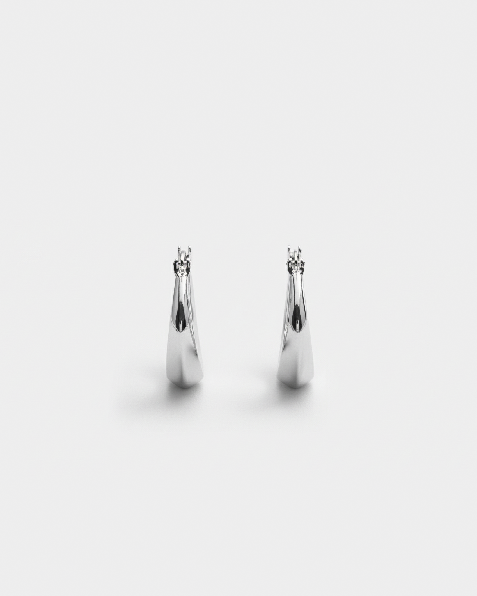 ahrensandco Paradoxe Earring – asymmetrische skulpturale Creolen aus Edelstahl mit polierter Oberfläche, minimalistisches Design aus Paris
